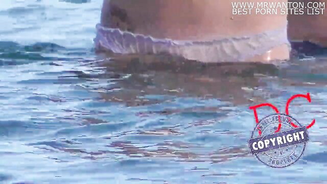 Beach girl swims in wet see-through panties, teasing ass view