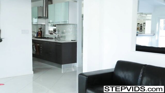 Emma Hix in modern kitchen with black leather couch