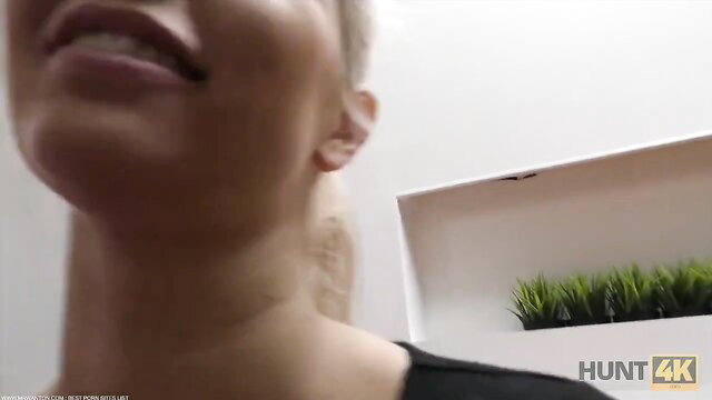 Blonde in black top smiles at HUNT4K cash offer from stranger