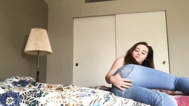 Hottie in tight jeans and heels poses on bed showing off feet