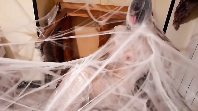 Nude woman trapped in thick white spider webs, BDSM bondage tease