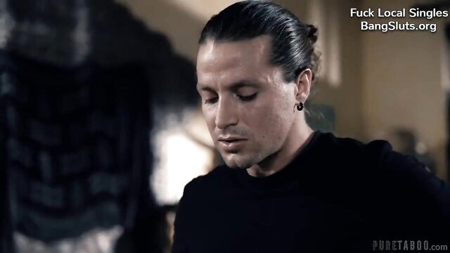 Handsome man with man bun stares intensely, BangSluts ad overlay