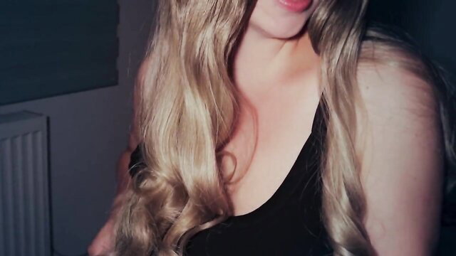 Blonde babe in tight black top with deep cleavage, seductive gaze