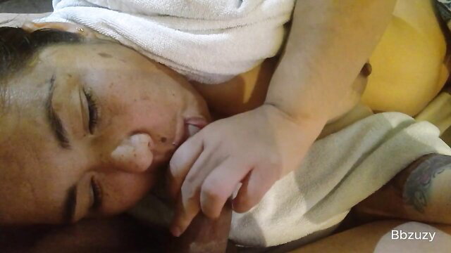 Asian mom breastfeeding baby in towel, intimate closeup suckling