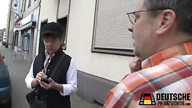 Asian woman in vest hat chats with men on German street amateur tease