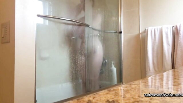Silhouetted nude woman showering, magic tits and ass visible through foggy glass
