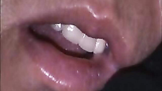 Amateur closeup of woman's glossy lips and white teeth smiling seductively