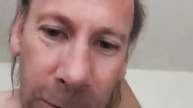 Balding old man with ponytail stares intensely in closeup thumbnail