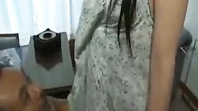 Japanese woman in sheer dress stands over man sitting on chair