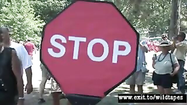 Amateur public party crowd with huge STOP sign prop