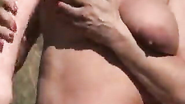 Horny MILF hands on buff guy's chest in outdoor sex scene