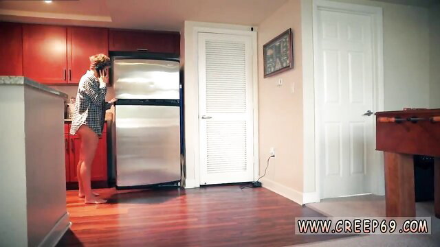 Bent over redhead in shorts opens fridge in kitchen tease