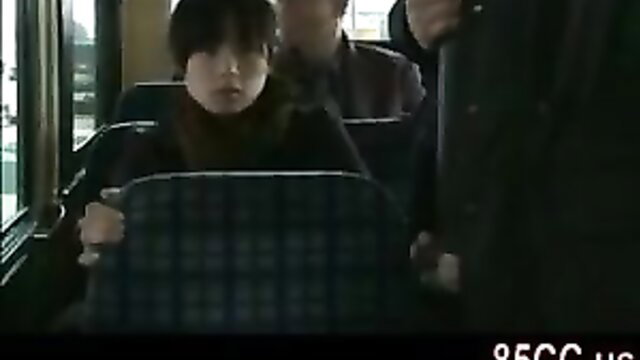 Cute Asian teen girl in black turtleneck on bus with men