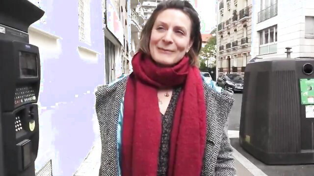 Mature brunette MILF in coat and red scarf on street, smiling seductively