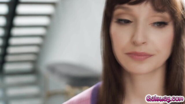 Closeup of sexy brunette with bangs in purple top, sultry gaze