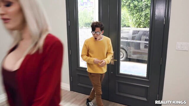 Busty blonde MILF greets nerdy teen guy at door in tight red top