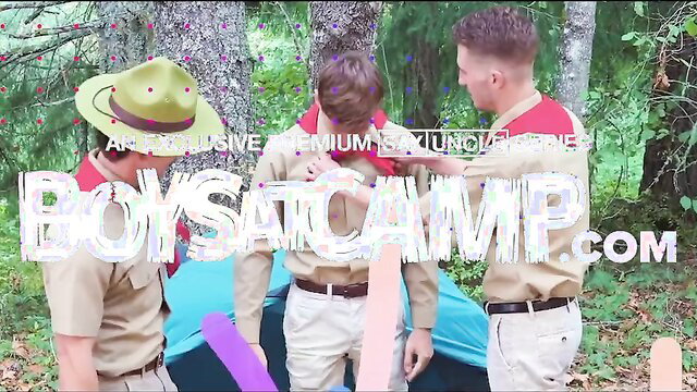 3 cute twink scouts in uniforms by tent at boys camp