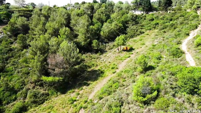 Drone view of young couple fucking outdoors in lush green hills