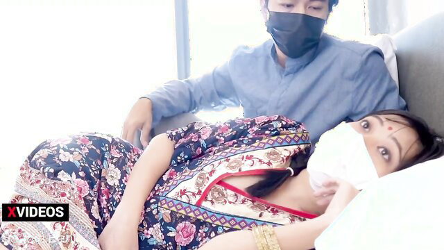 Desi wife in floral saree lies with masked man on couch, teasing gaze