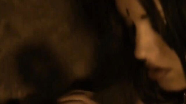 Indian cougar with black hair teases in dark lighting, seductive profile view