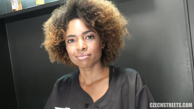 Czech Streets black sexy hairdresser with curly afro hair smiling
