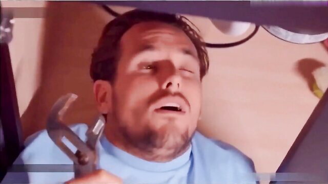 Alura Jenson plumber under sink holding wrench closeup face