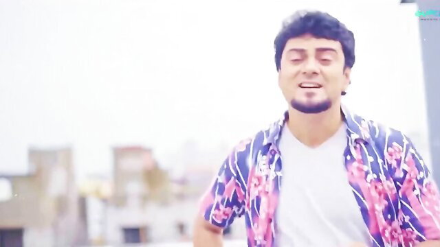 Handsome Indian man singing on rooftop in colorful shirt