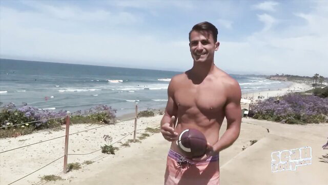Shirtless hunk with football on beach in swim trunks pickup tease