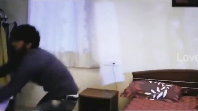 South Indian man kneeling by bed in amateur bedroom scene