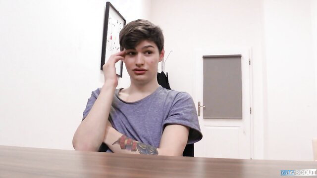 Androgynous twink with tattoos thinks while eyeing camera in job interview tease