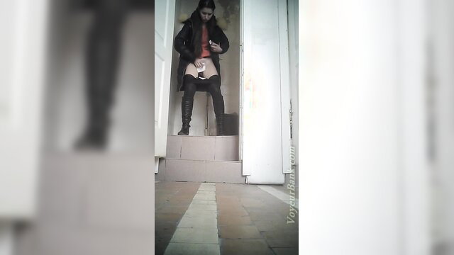 White chick in black boots and pantyhose stands at toilet Voyeur Bank