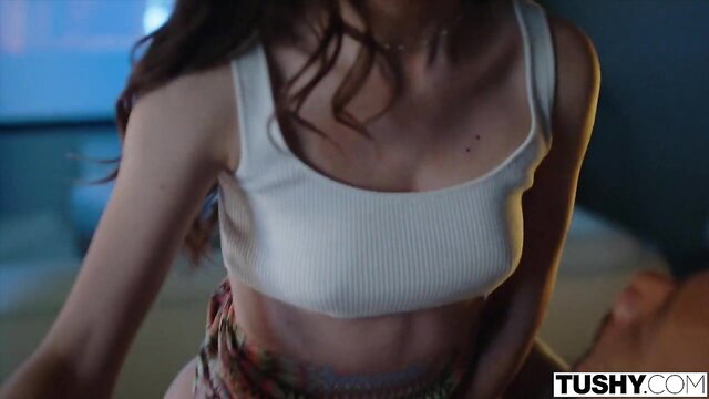 Maya Woulfe in tight white tank top and skirt, teasing curves