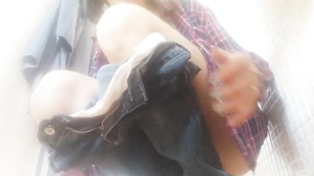 Amateur bride-to-be in plaid shirt and jeans holds head near crotch in shower stall