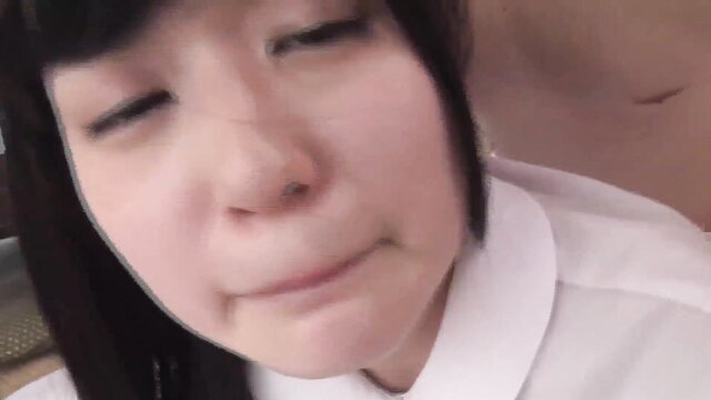 Naughty Asian schoolgirl with bangs smirks closeup before facial cumshot