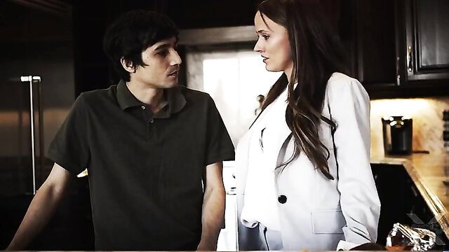 Pristine Edge in tight white blazer chats with young guy in kitchen