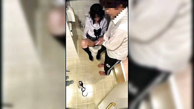 Japanese schoolgirl in skirt squatting on toilet with man filming in bathroom