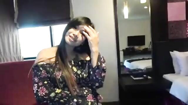 Cheating Asian wife covers eyes smiling in hotel room tease