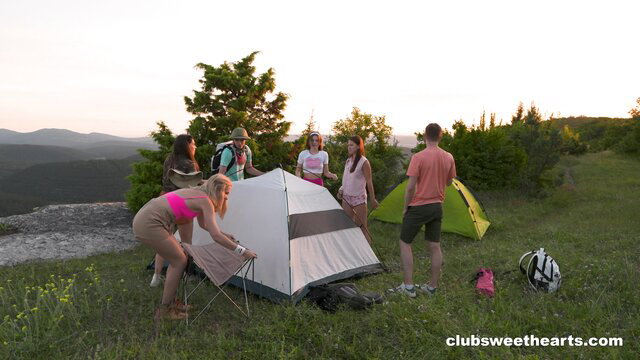 Hot blondes in bikinis setting up tents with guys at sunset campsite