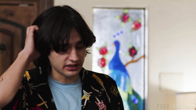 Elias Cash scratching head in colorful shirt, peacock art background