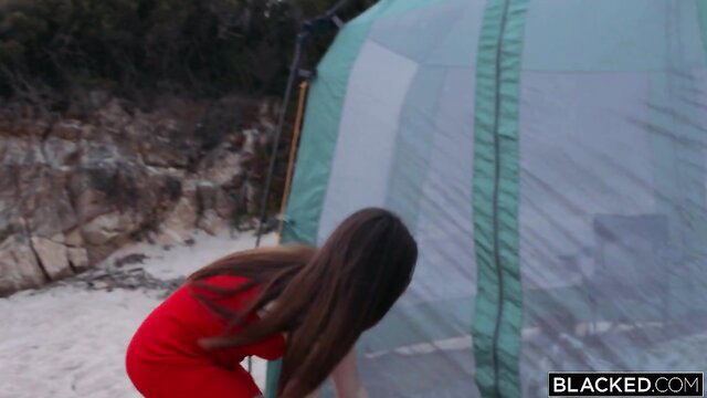 Victoria Bailey in red dress bending over tent in Blacked interracial scene