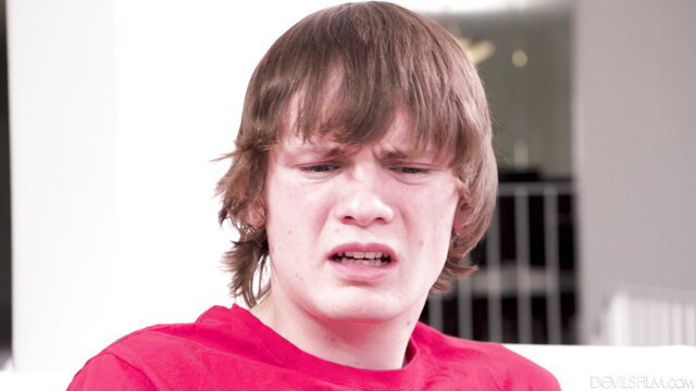 Crying shaggy-haired twink in red shirt - emotional young guy closeup