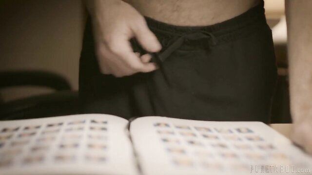 Michael Vegas untying sweatpants over open photo book in Pure Taboo