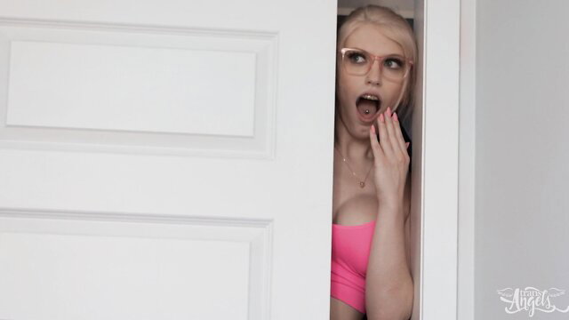 Izzy Wilde peeking from door in pink top, shocked expression