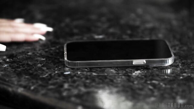 Ella Reese's elegant hand near clear iPhone on black granite table