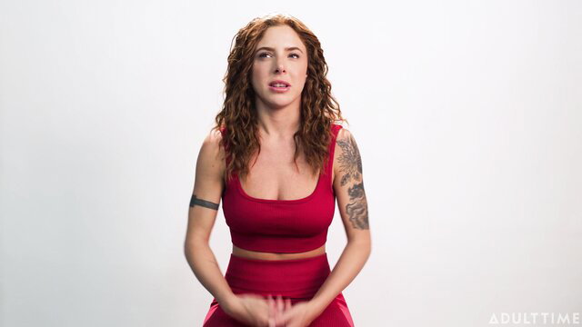 Lumi Ray in red tank top, tattooed arm, solo interview