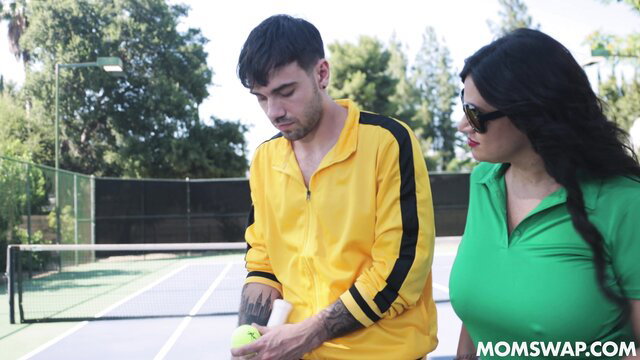 Mona Azar in yellow tracksuit with tennis ball at court, sexy green polo