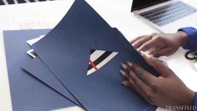 Ana Foxxx holds blue folder with Korra Del Rio logo in office