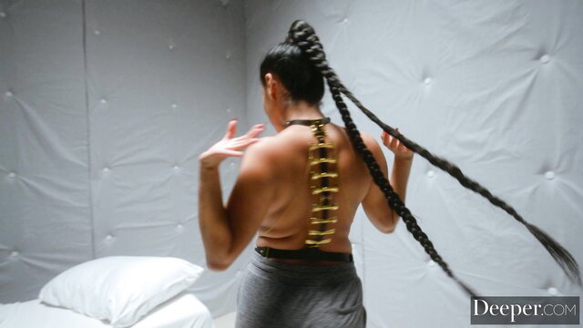 Vicki Chase back view with spine chain, long black ponytail, sexy gray pants