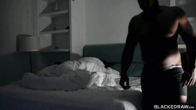 Prince Yahshua stands nude by bed over woman under sheets in Blacked Raw threesome