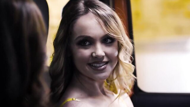 Blonde in yellow dress smiles seductively on bus in Pure Taboo scene